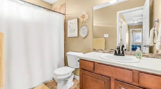 a bathroom with a granite countertop toilet sink and a mirror