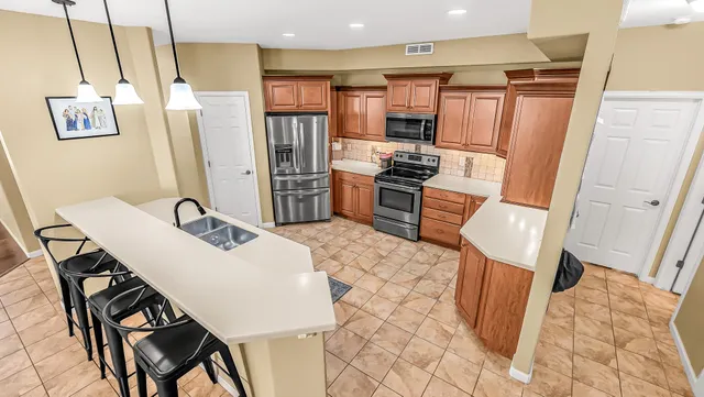 a kitchen with stainless steel appliances a refrigerator and a stove top oven