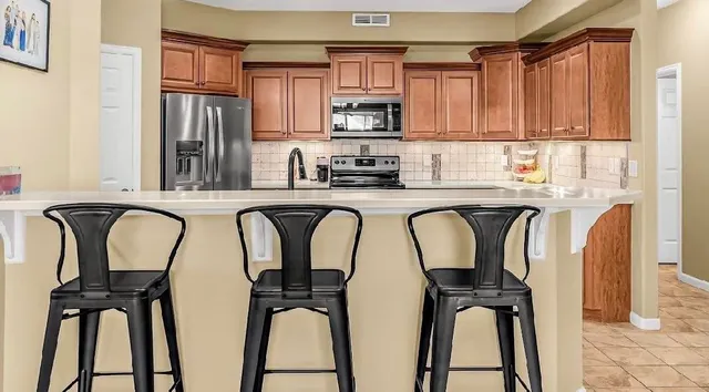 a kitchen with stainless steel appliances granite countertop a refrigerator a sink a stove and cabinets