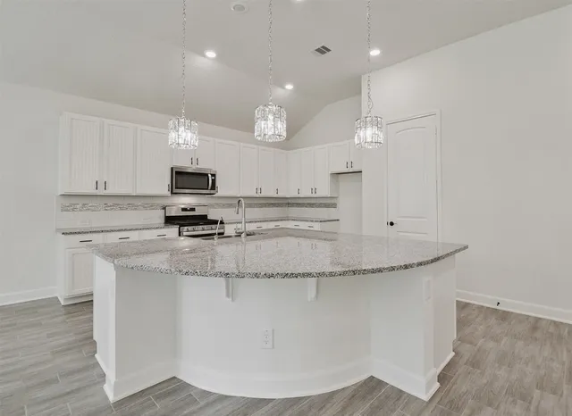 a kitchen with stainless steel appliances granite countertop a sink a microwave and cabinets