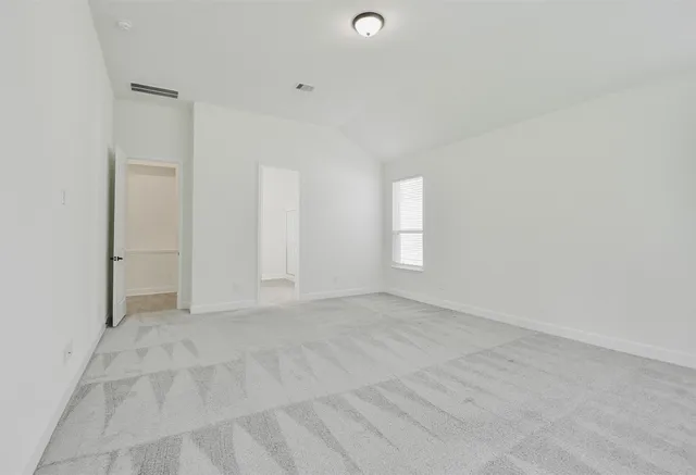 a view of an empty room with window and closet area