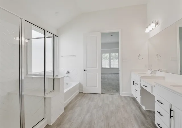 a spacious bathroom with a granite countertop sink a mirror a vanity and a bathtub