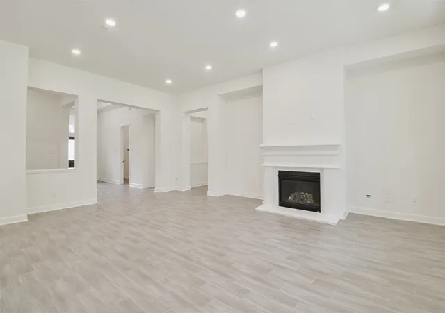 a view of empty room with wooden floor and fireplace