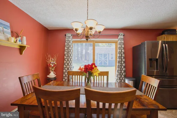 a dining room with furniture a large window and wooden floor