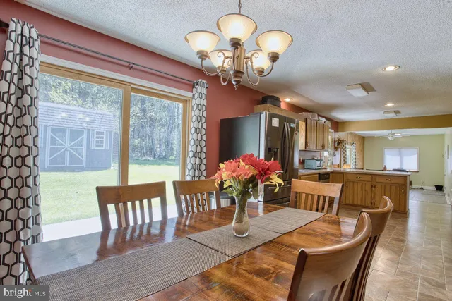 a view of a dining room with furniture a chandelier and wooden floor