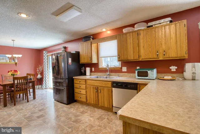 a kitchen with stainless steel appliances granite countertop a refrigerator and cabinets