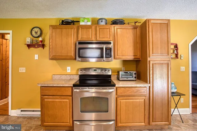 a kitchen with a dining table chairs and refrigerator