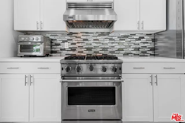 a stove top oven sitting inside of a kitchen