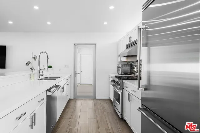 a kitchen with cabinets stainless steel appliances and a sink