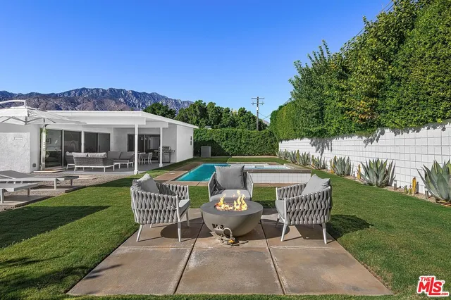 a patio with table and chairs and potted plants