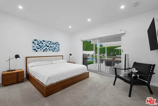 a bed sitting in a spacious bedroom next to a window