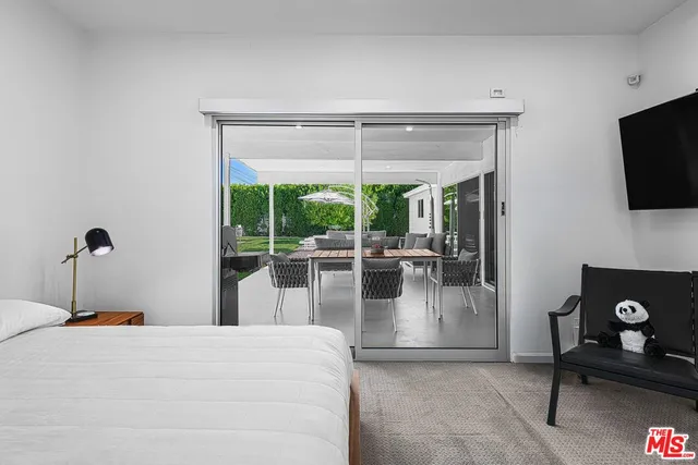 a living room with furniture a flat screen tv and a floor to ceiling window