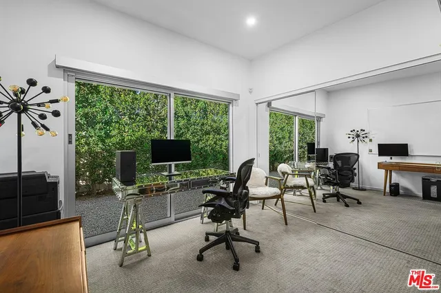 a view of a livingroom with workspace and a window