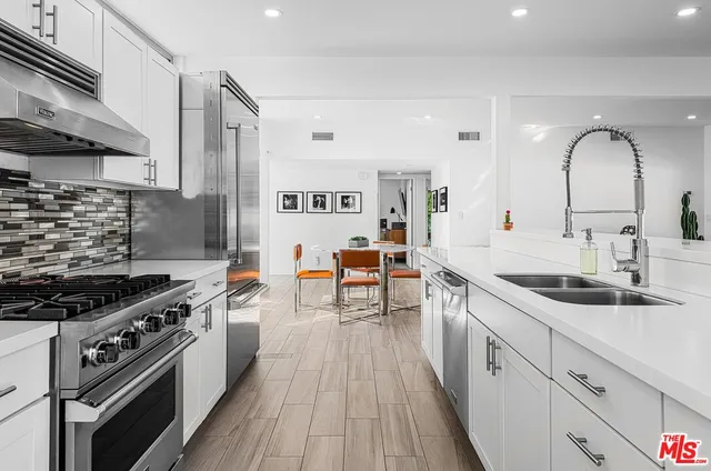 a kitchen with sink stove and cabinets