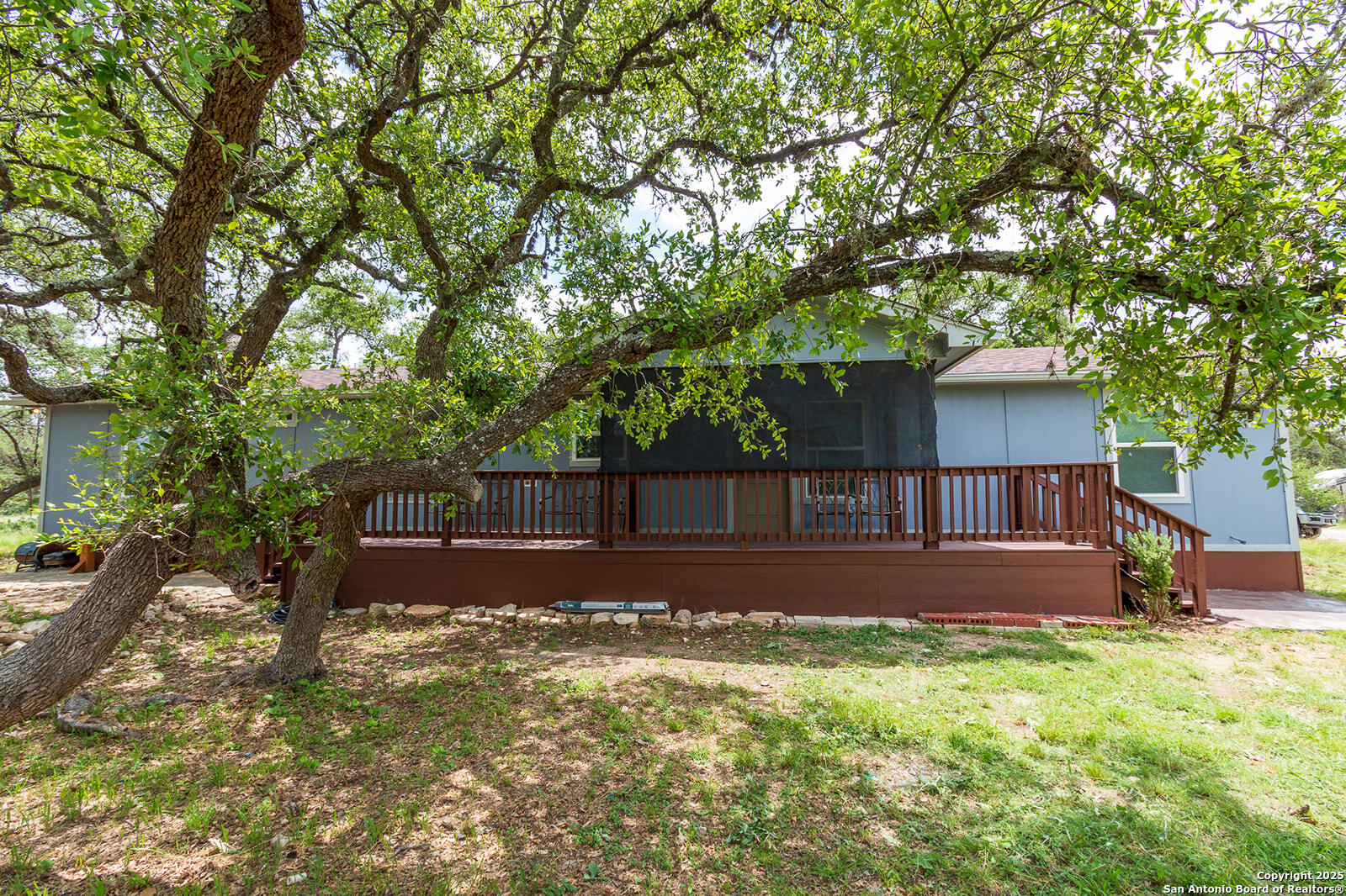 a view of house with backyard and trees