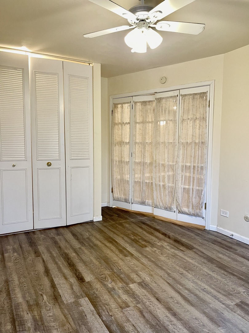 706 East Algonquin Road, Unit 204 Arlington Heights, IL 60005 - Photo 12 of 15 a view of an empty room with wooden floor and a window