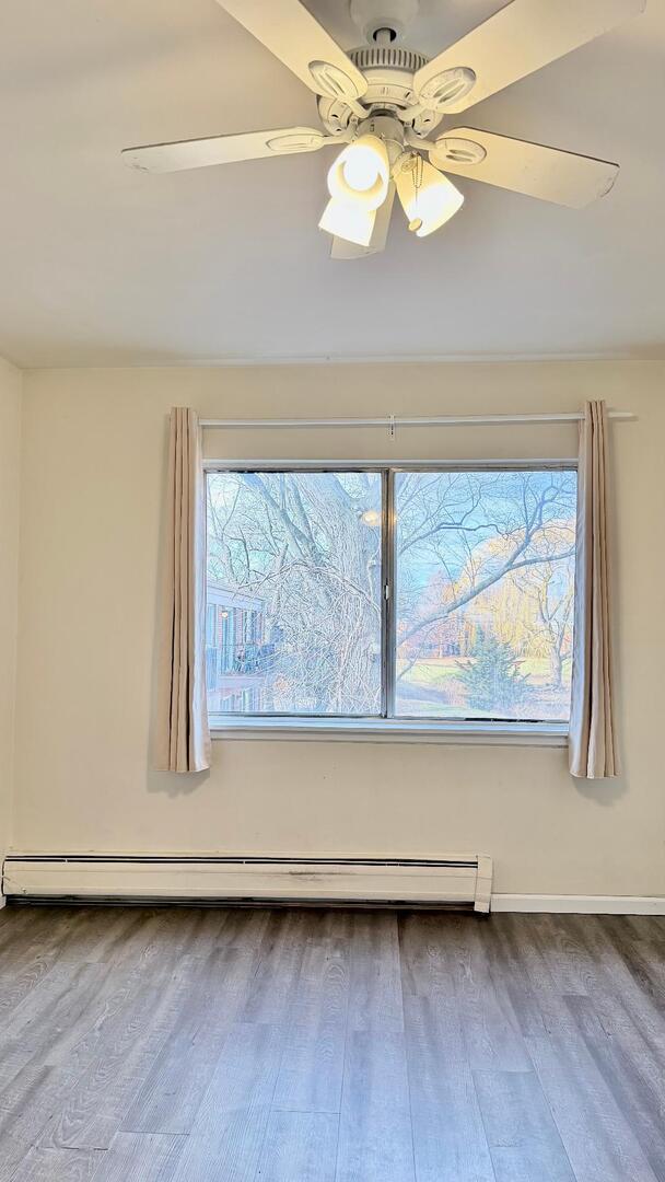 706 East Algonquin Road, Unit 204 Arlington Heights, IL 60005 - Photo 13 of 15 a view of wooden floor and a chandelier fan in a room