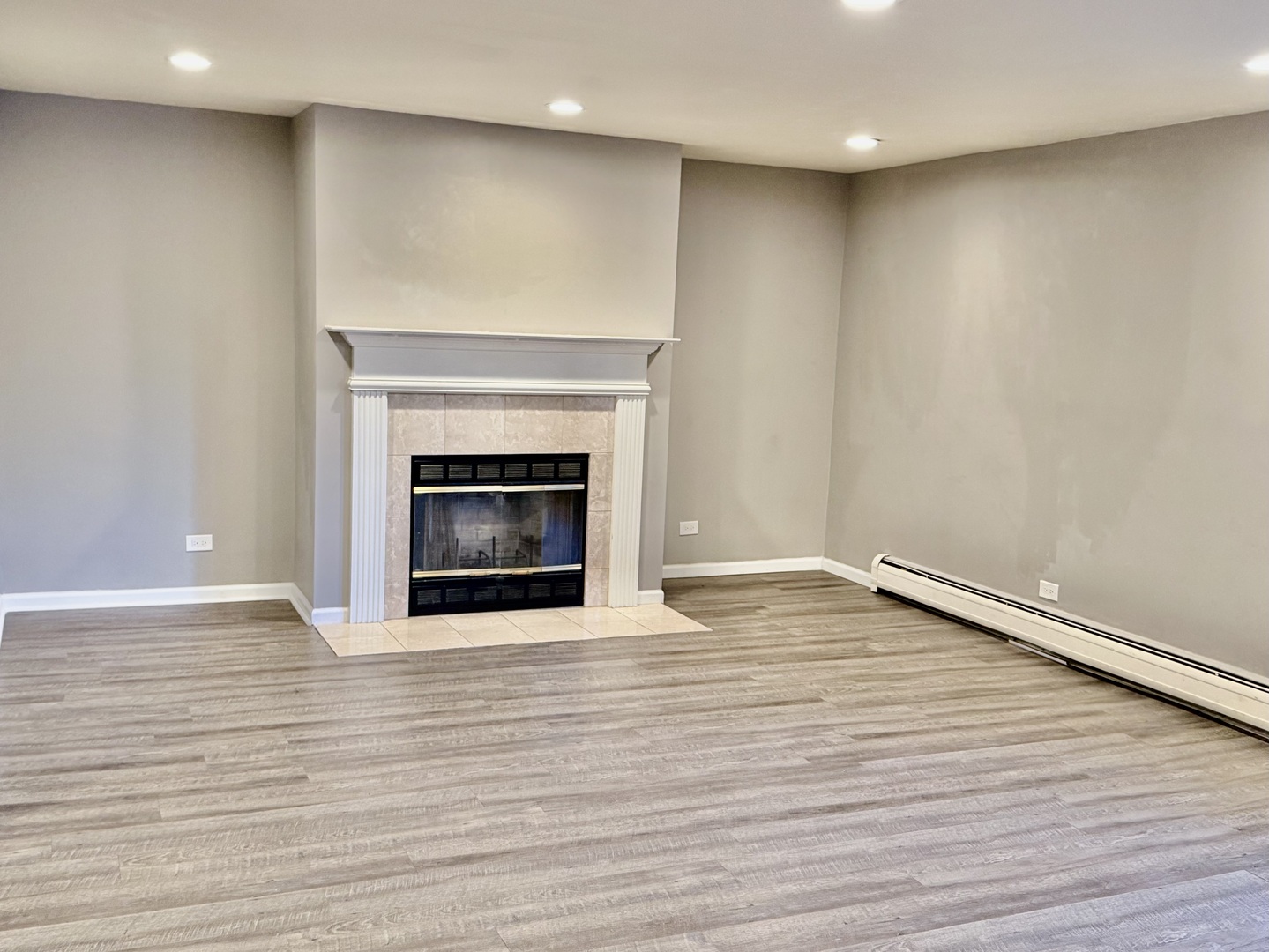 706 East Algonquin Road, Unit 204 Arlington Heights, IL 60005 - Photo 5 of 15 a view of empty room with wooden floor and fireplace