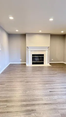 a view of empty room with wooden floor and fireplace