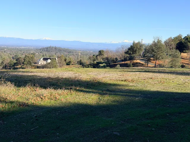 a view of a dry yard with mountains in the background