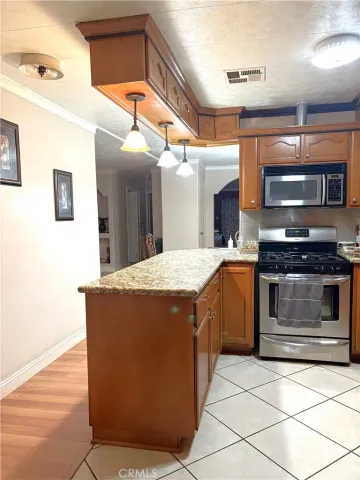 a kitchen with stainless steel appliances kitchen island granite countertop a stove a sink and a microwave
