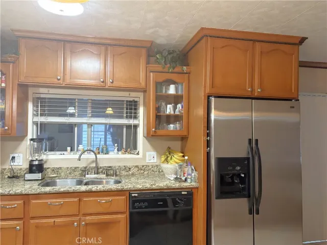 a kitchen with granite countertop stainless steel appliances and refrigerator