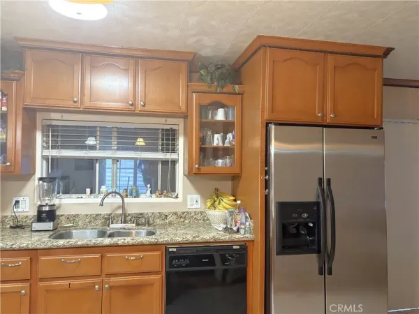 a kitchen with granite countertop stainless steel appliances and refrigerator