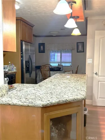 a kitchen with kitchen island granite countertop wooden cabinets and a refrigerator