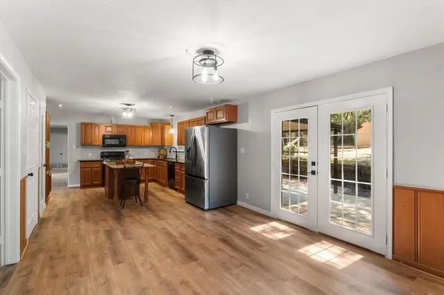 a view of kitchen with stainless steel appliances refrigerator stove and wooden cabinets