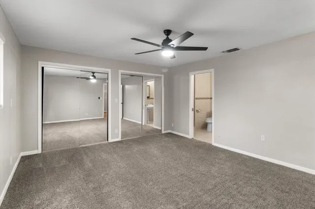 a view of an empty room and window ceiling fan