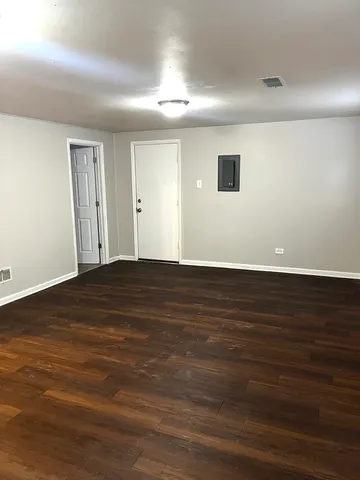 a view of an empty room with wooden floor
