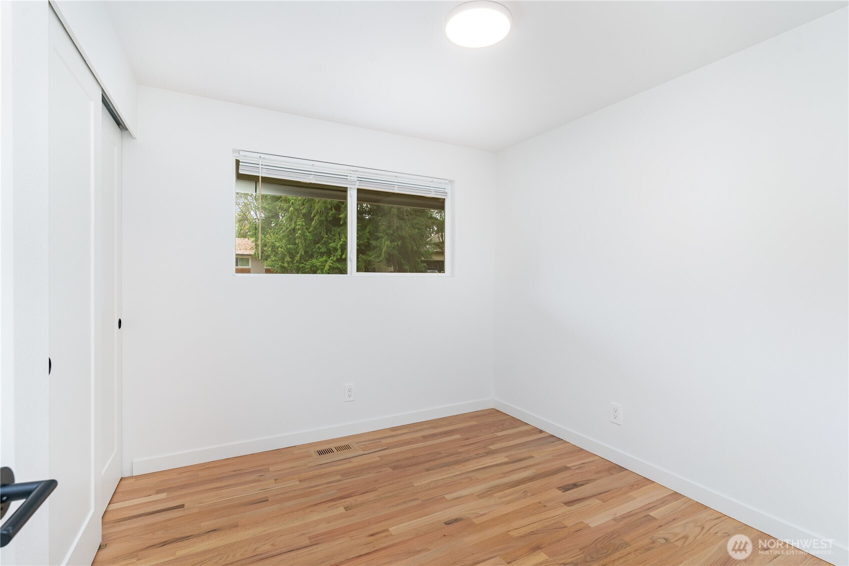 8428 Northeast 132nd Place Kirkland, WA 98034 - Photo 14 of 30 a view of an empty room with wooden floor and a window