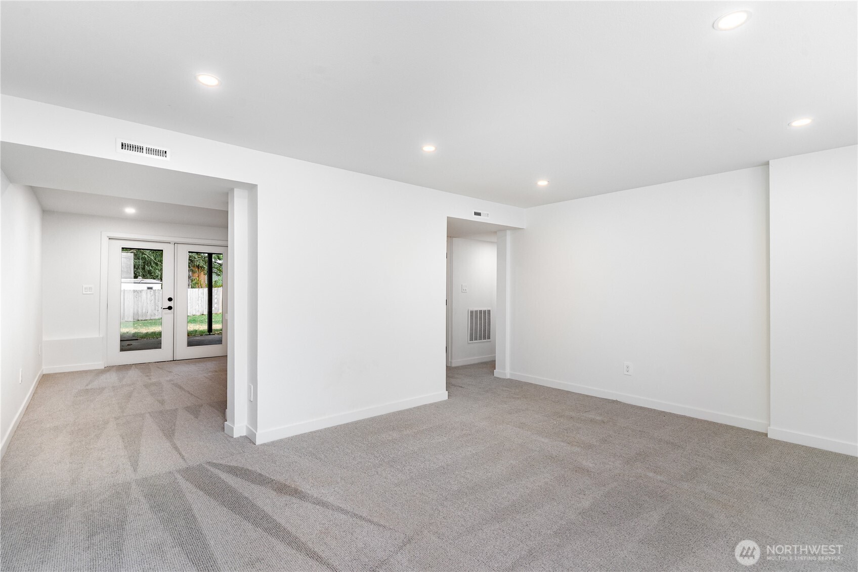 8428 Northeast 132nd Place Kirkland, WA 98034 - Photo 22 of 30 an empty room with wooden floor and way to kitchen