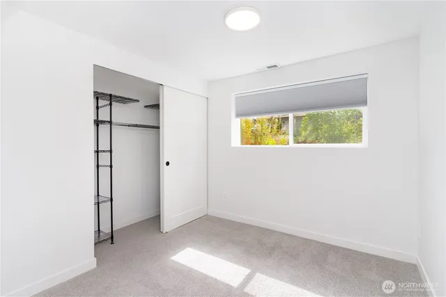 an empty room with a window and a bathroom