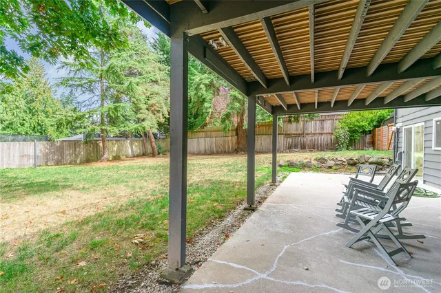 a view of a patio with table and chairs and floor to ceiling window