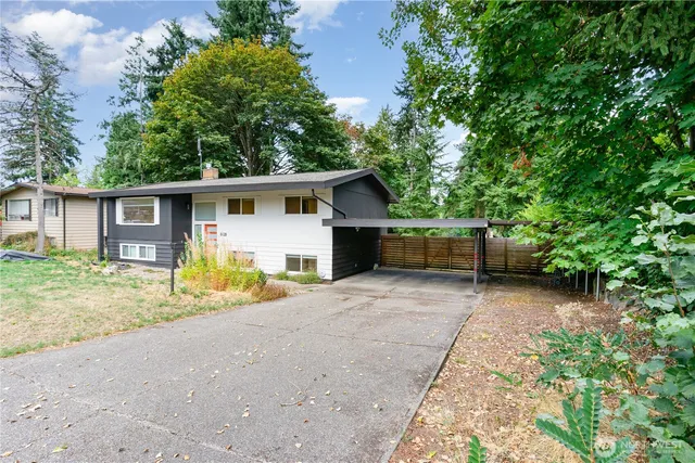 a view of a house with backyard and trees