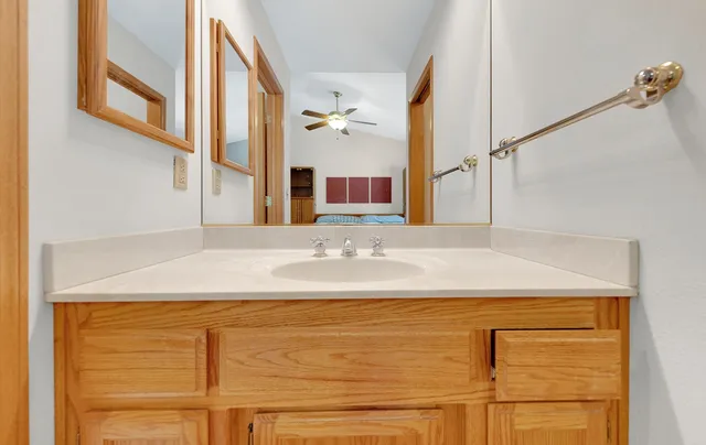 a bathroom with a granite countertop sink and a mirror