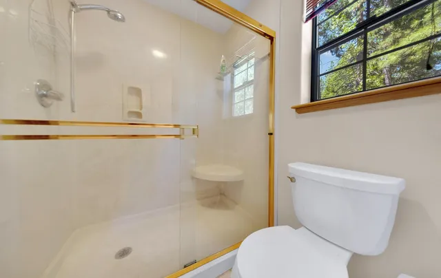 a white toilet sitting next to a bathroom sink and tub