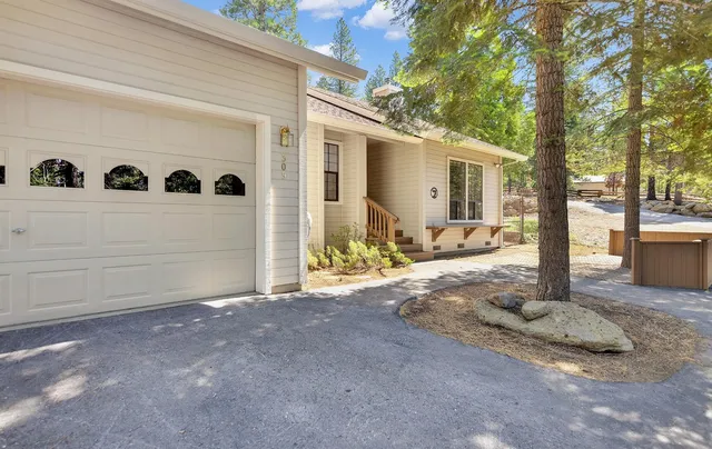 a view of a house with backyard and trees