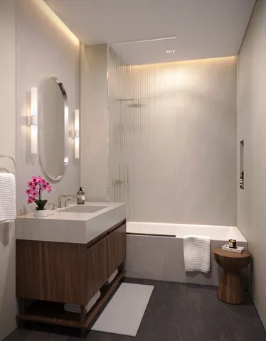 a bathroom with a bathtub sink and mirror