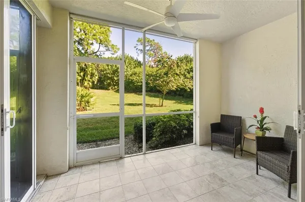 a view of a room with a table and chairs potted plants next to a large window