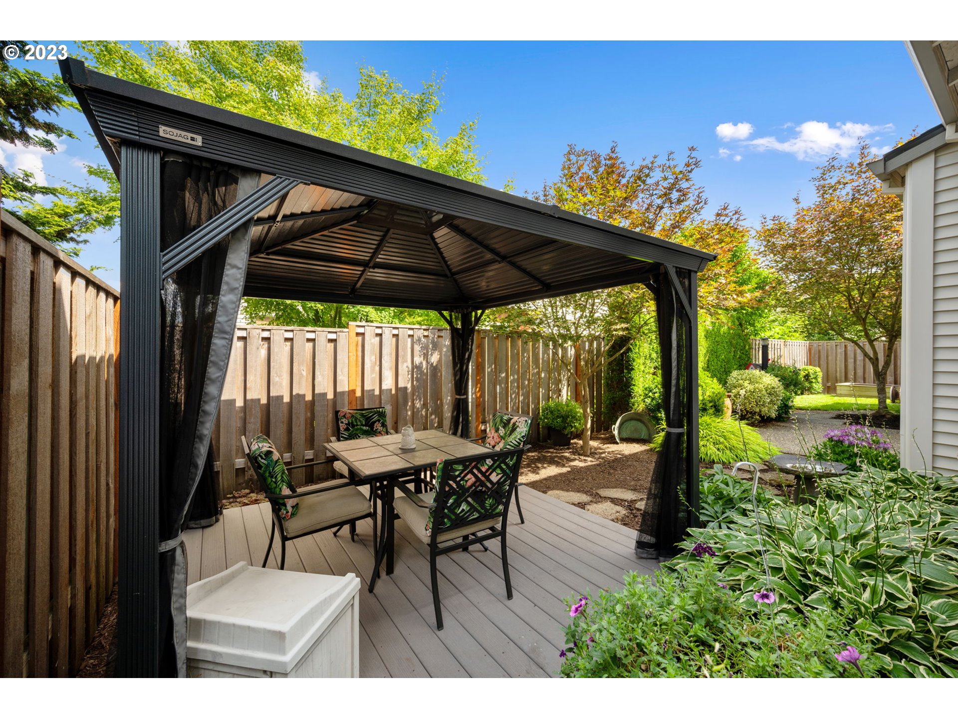 8627 Southwest Lodi Lane Portland, OR 97224 - Photo 36 of 41 a view of a patio with table and chairs under an umbrella with a small yard