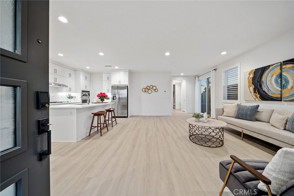 131 Restore Irvine, CA 92618 - Photo 3 of 43 a living room with furniture and kitchen view with wooden floor