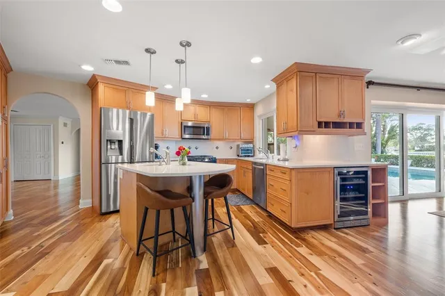 a dining hall with stainless steel appliances granite countertop a sink and a large window