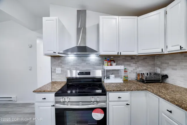 a kitchen with a stove and white cabinets