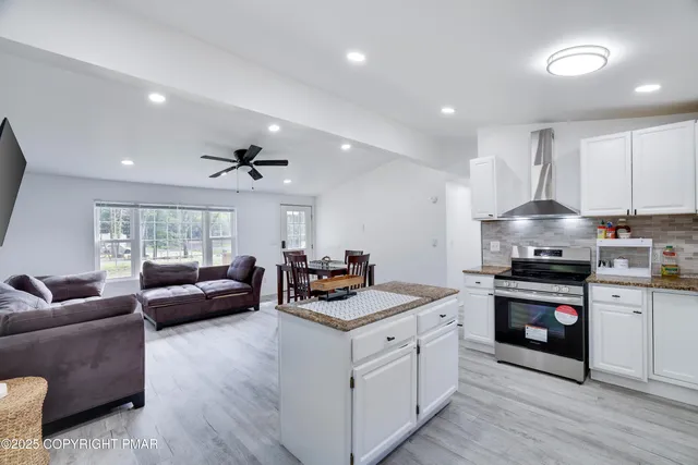 a open kitchen with stainless steel appliances granite countertop a stove and a sink