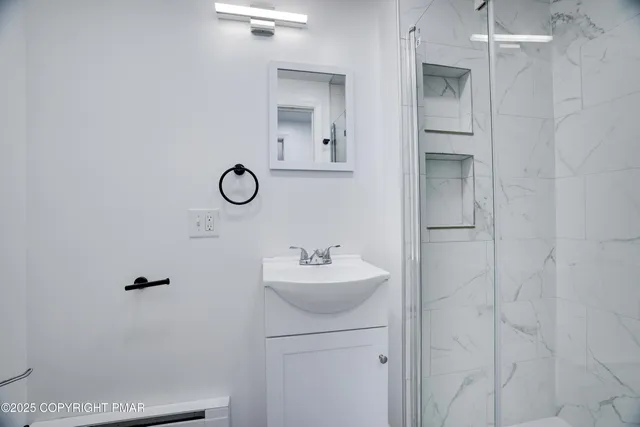 a bathroom with a sink shower and a mirror