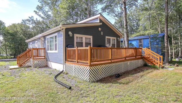 a view of a house with a yard and deck