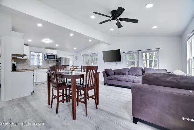 a living room with furniture kitchen and a dining table