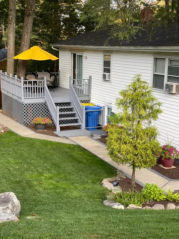 a view of a house with a backyard and furniture
